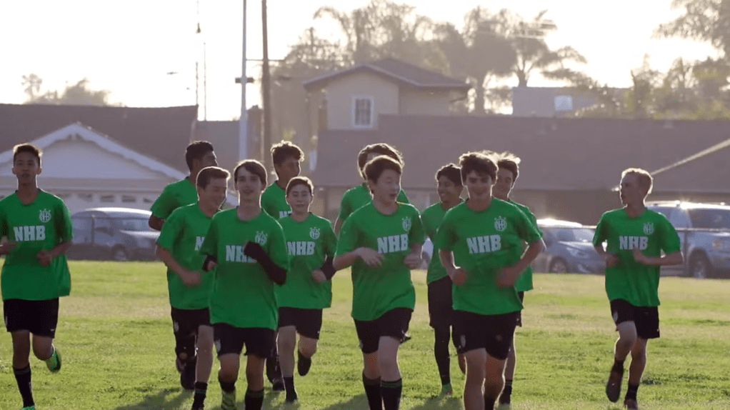 Players running on soccer field